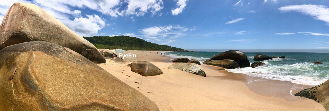 Panoramic view of rocks on beach against sky