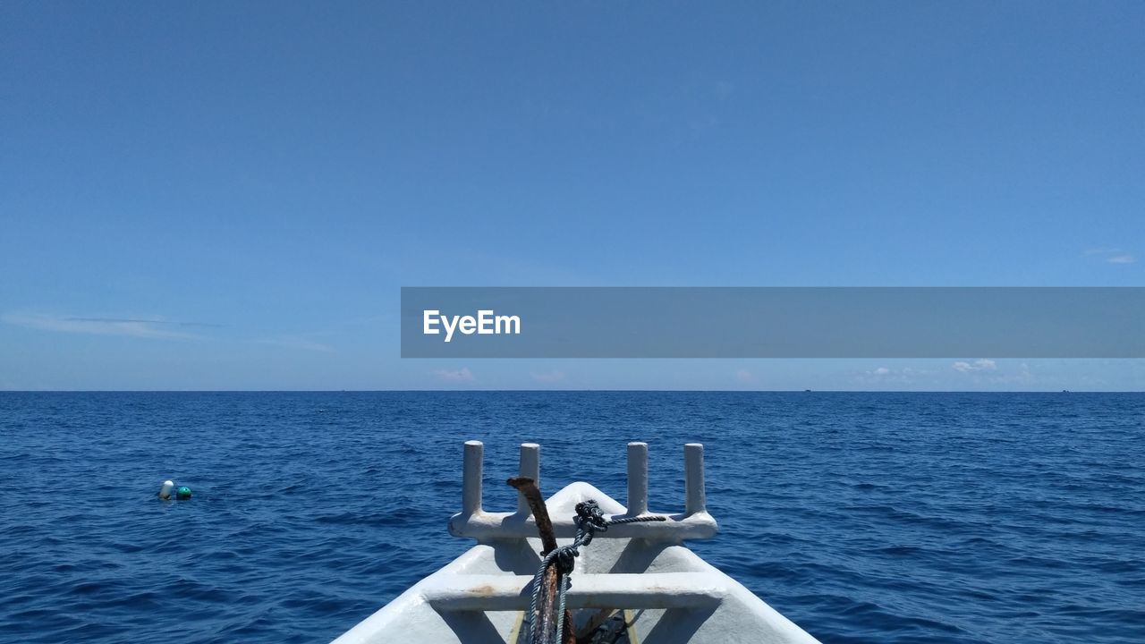 BOAT IN SEA AGAINST BLUE SKY