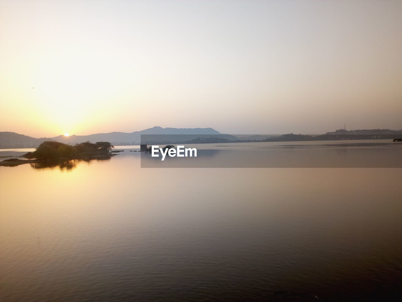 Scenic view of lake against sky during sunset