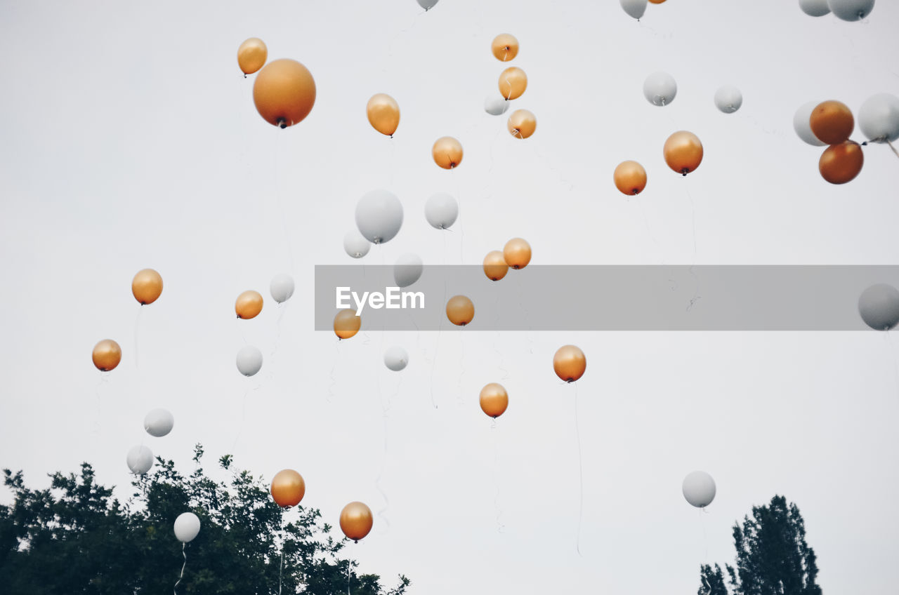 Low angle view of balloons flying against clear sky