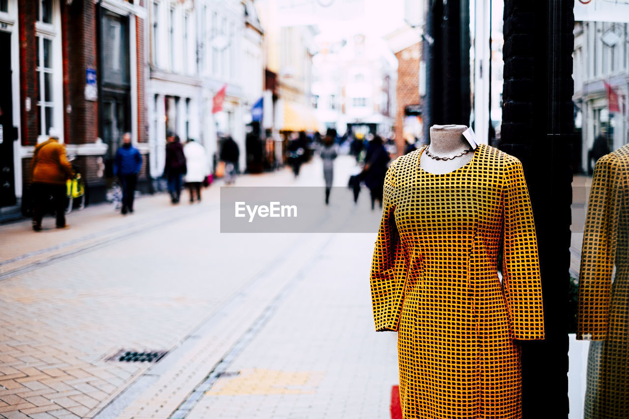 Front view dress with silhouette of people walking on street in city