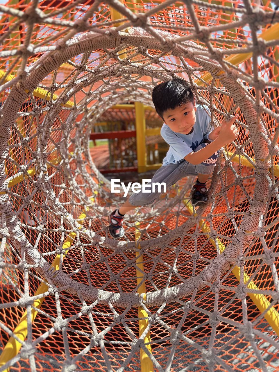 Full length of  children standing on chainlink fence