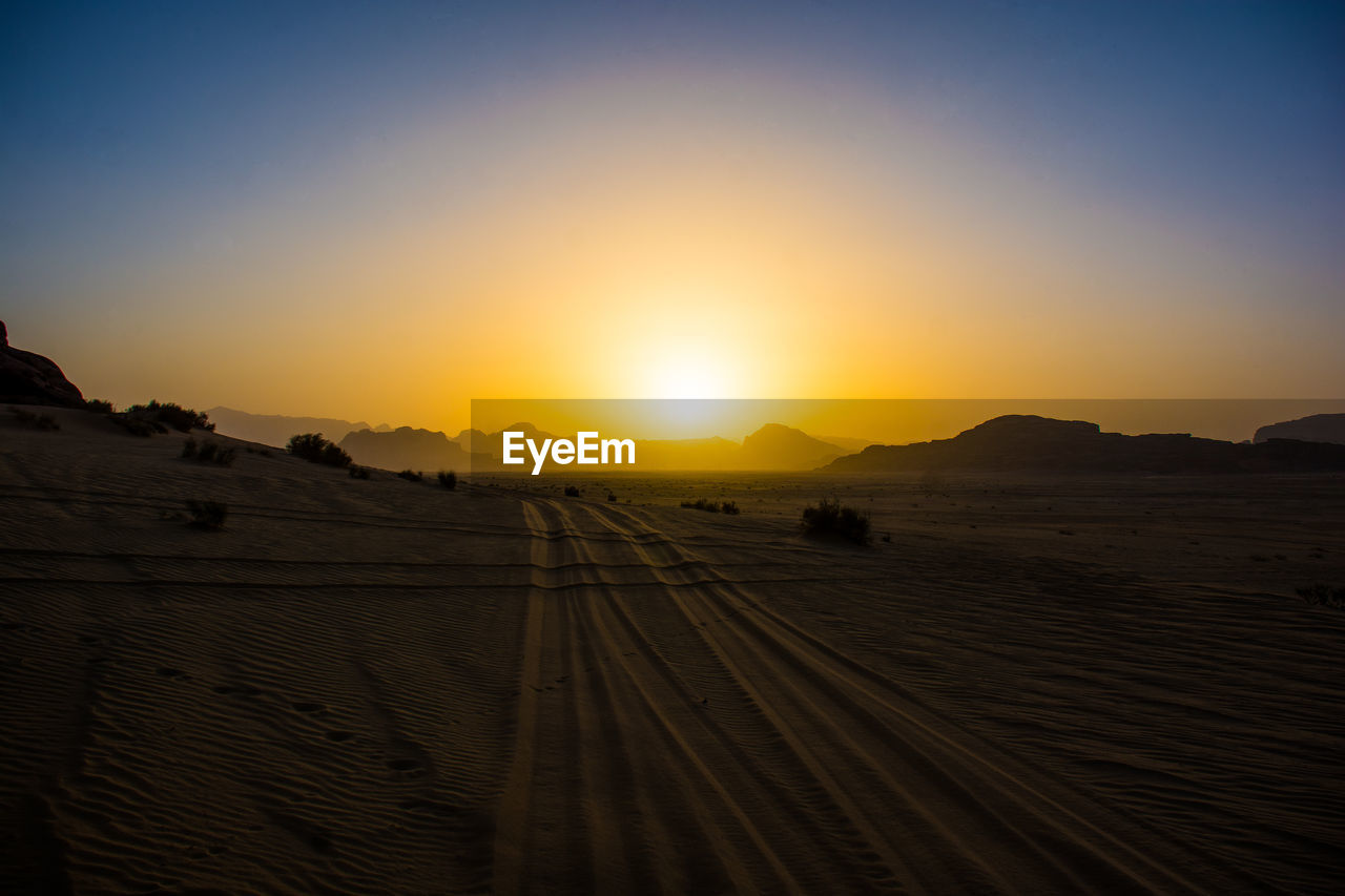 Scenic view of desert against sky during sunset