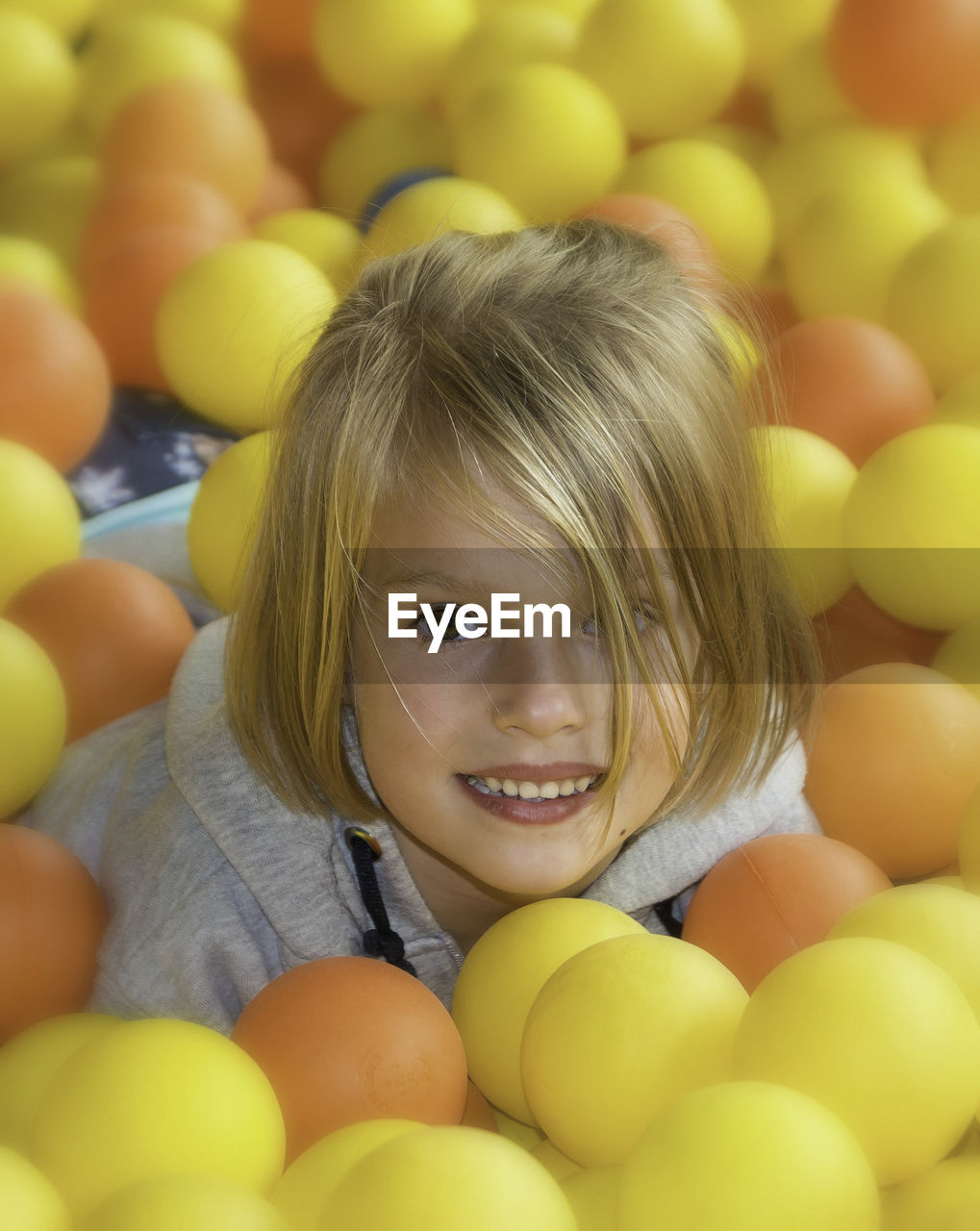 Portrait of girl amidst yellow and orange balloons