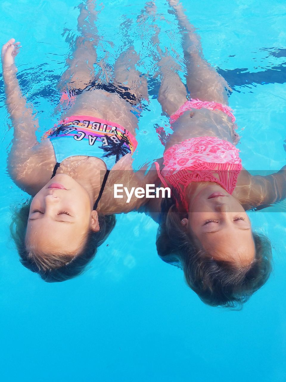 High angle view of two girls swimming in pool