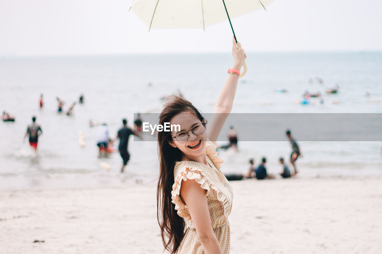 Portrait of young woman standing on beach