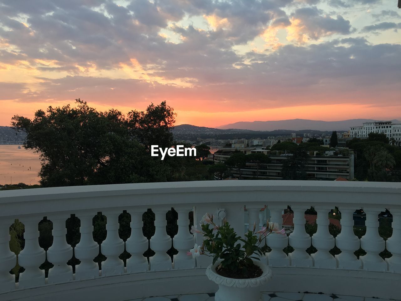 SCENIC VIEW OF RIVER AGAINST CLOUDY SKY AT SUNSET