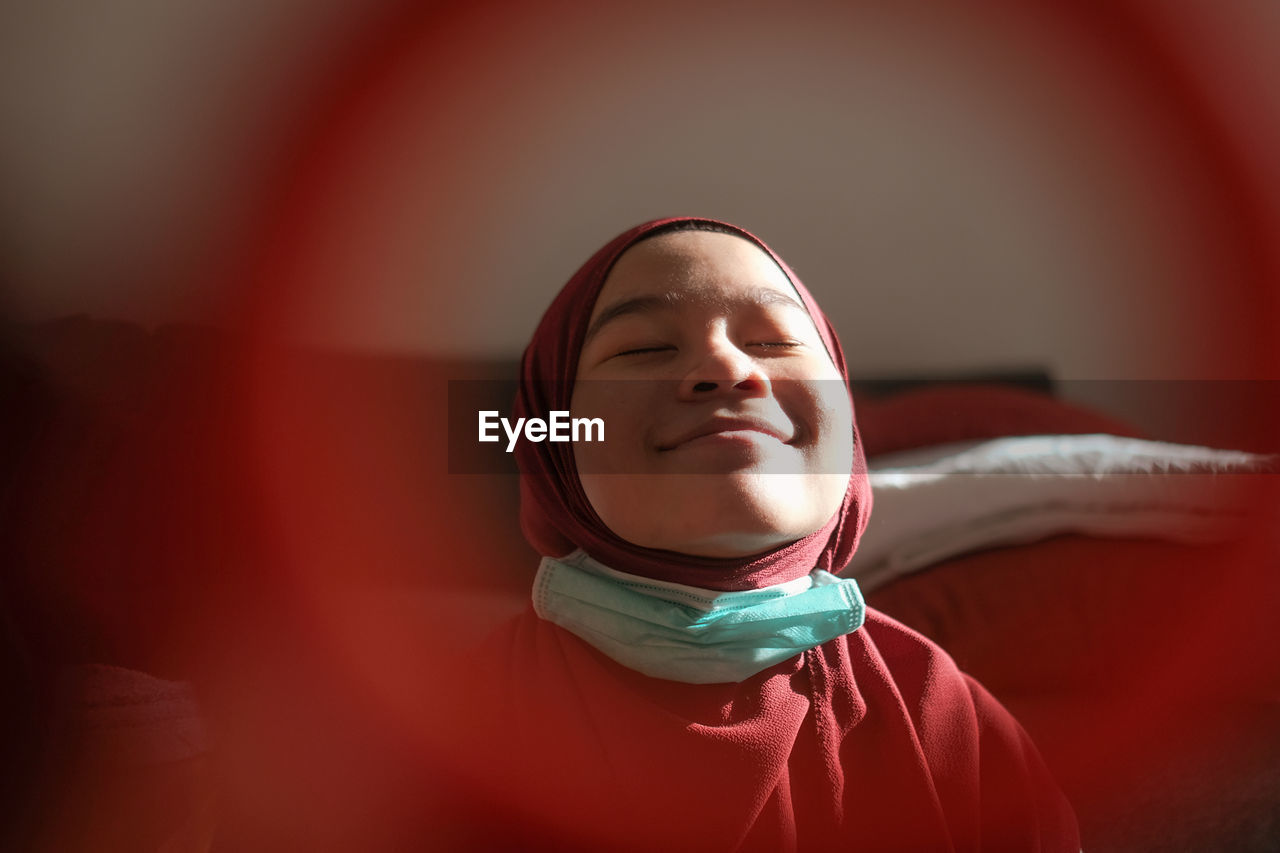 Close-up of young woman wearing hijab at home