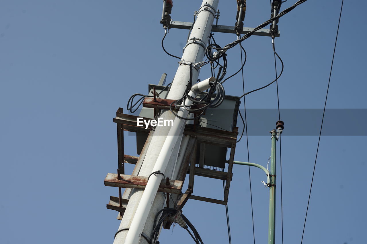 electricity, cable, sky, technology, power generation, low angle view, overhead power line, electrical supply, mast, clear sky, power supply, blue, electricity pylon, power line, nature, day, no people, public utility, lighting, communication, telephone pole, outdoors, antenna, complexity