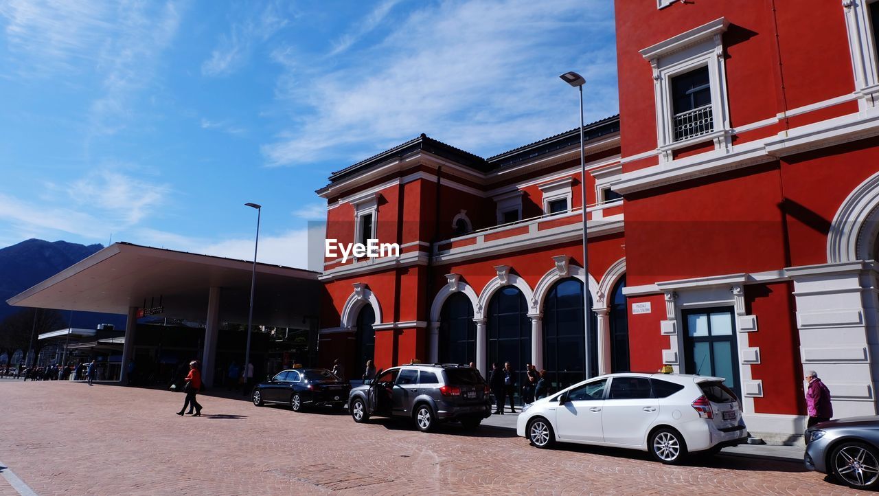 CARS ON STREET BY BUILDING AGAINST SKY