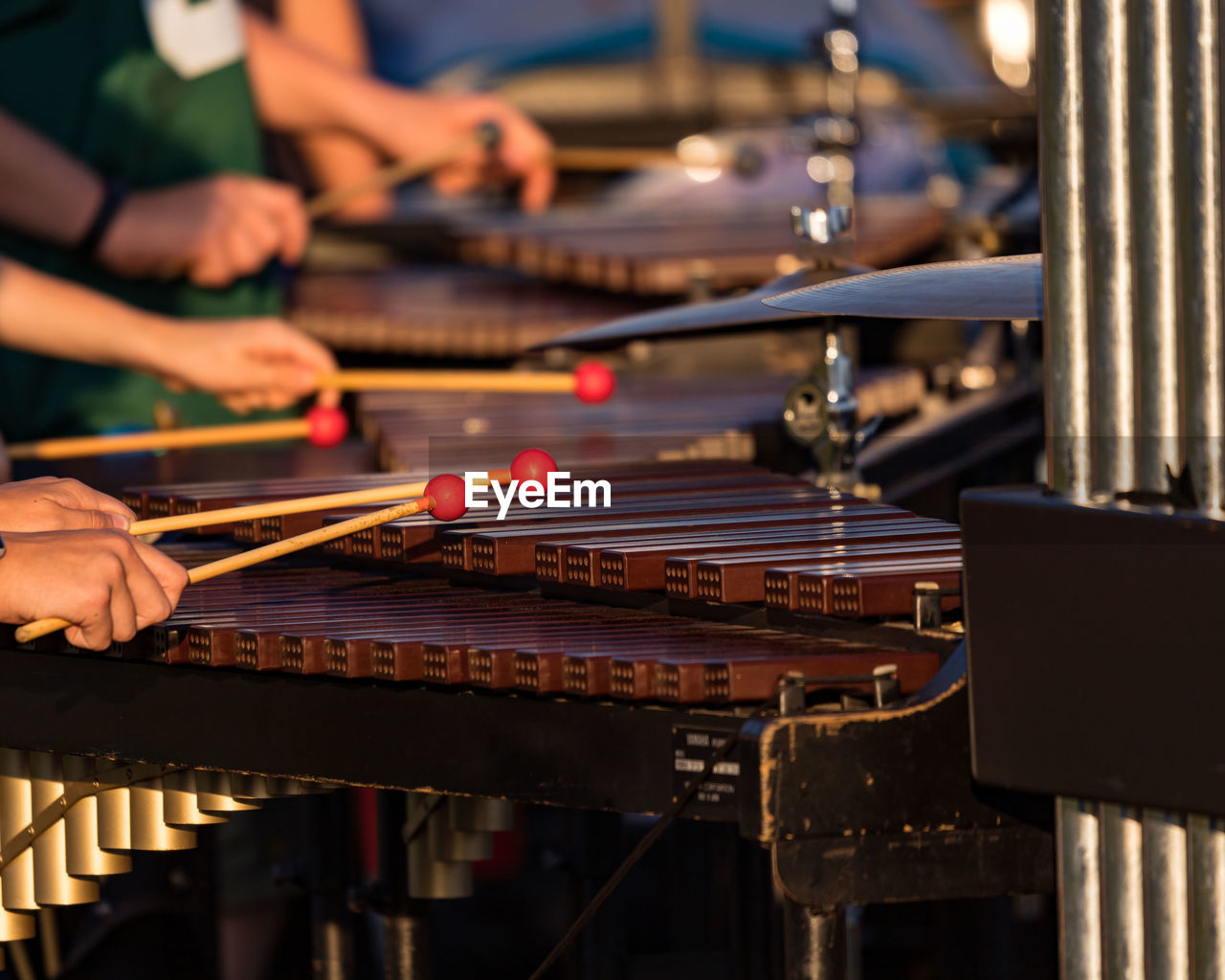 Several sideline percusionists performing at an outddors rehearsal