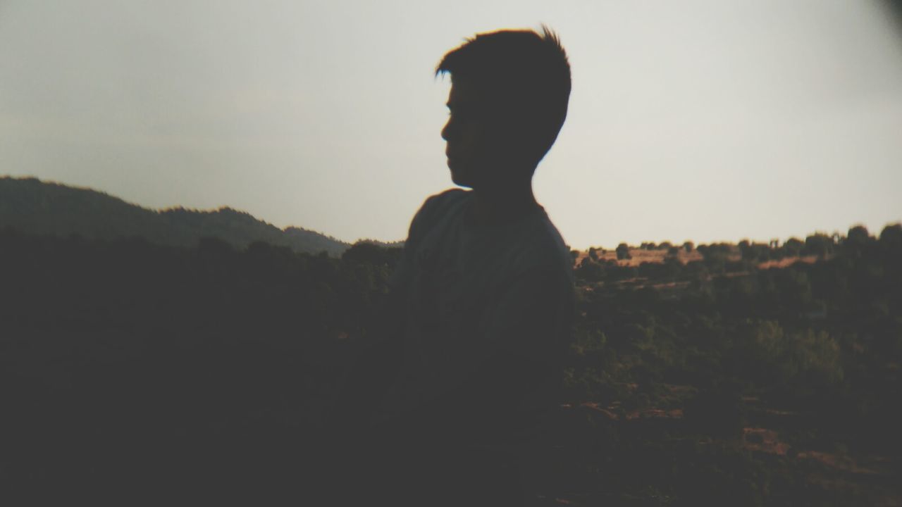 SILHOUETTE OF WOMAN STANDING ON MOUNTAIN AGAINST SKY