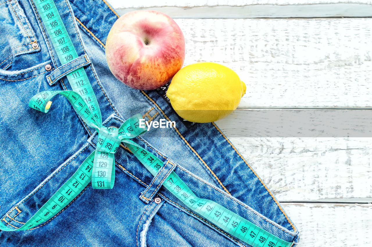 High angle view of jeans with fruit on table