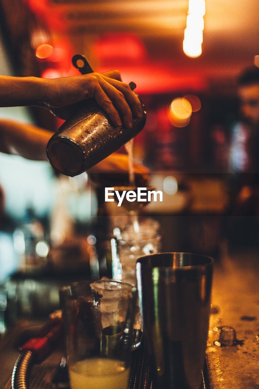 Cropped image of bartender making cocktail in bar