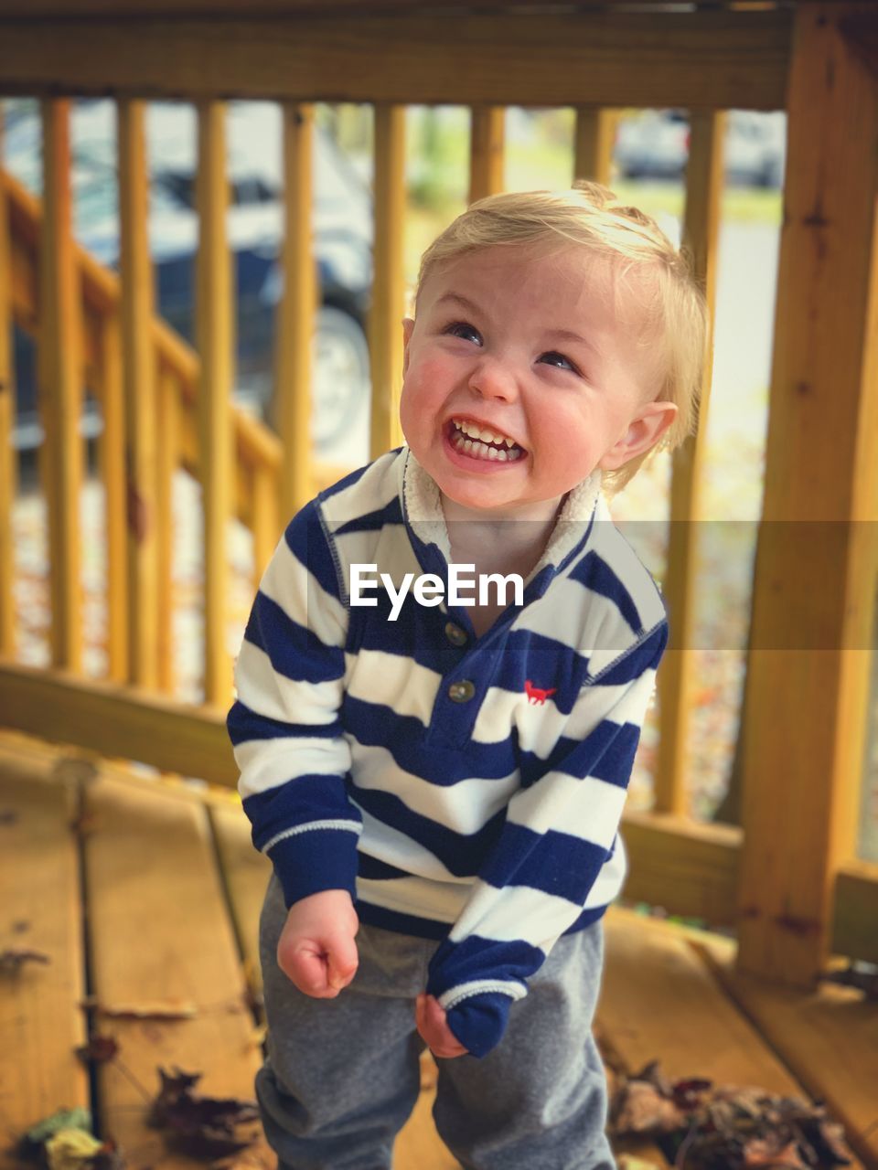 Blonde toddler boy in striped shirt laughing