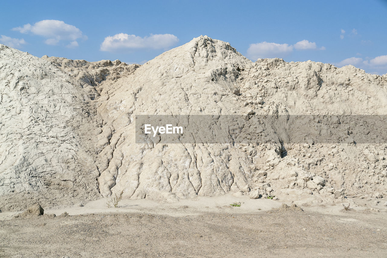 SCENIC VIEW OF ROCKS ON LAND AGAINST SKY