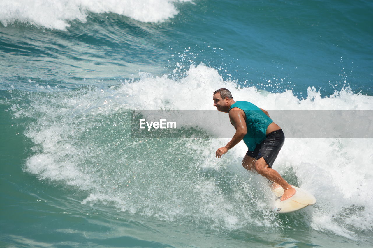 MAN SURFING ON SEA