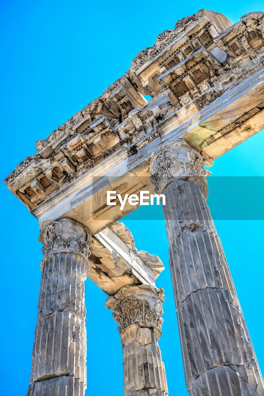 Low angle view of old ruins against blue sky