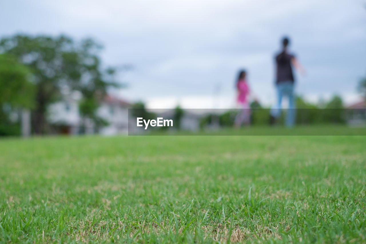 Man and woman on grass against sky