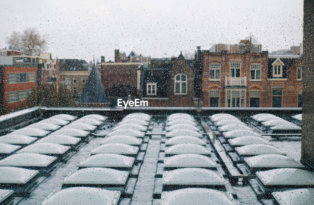 SNOW COVERED BUILDINGS AGAINST SKY DURING WINTER