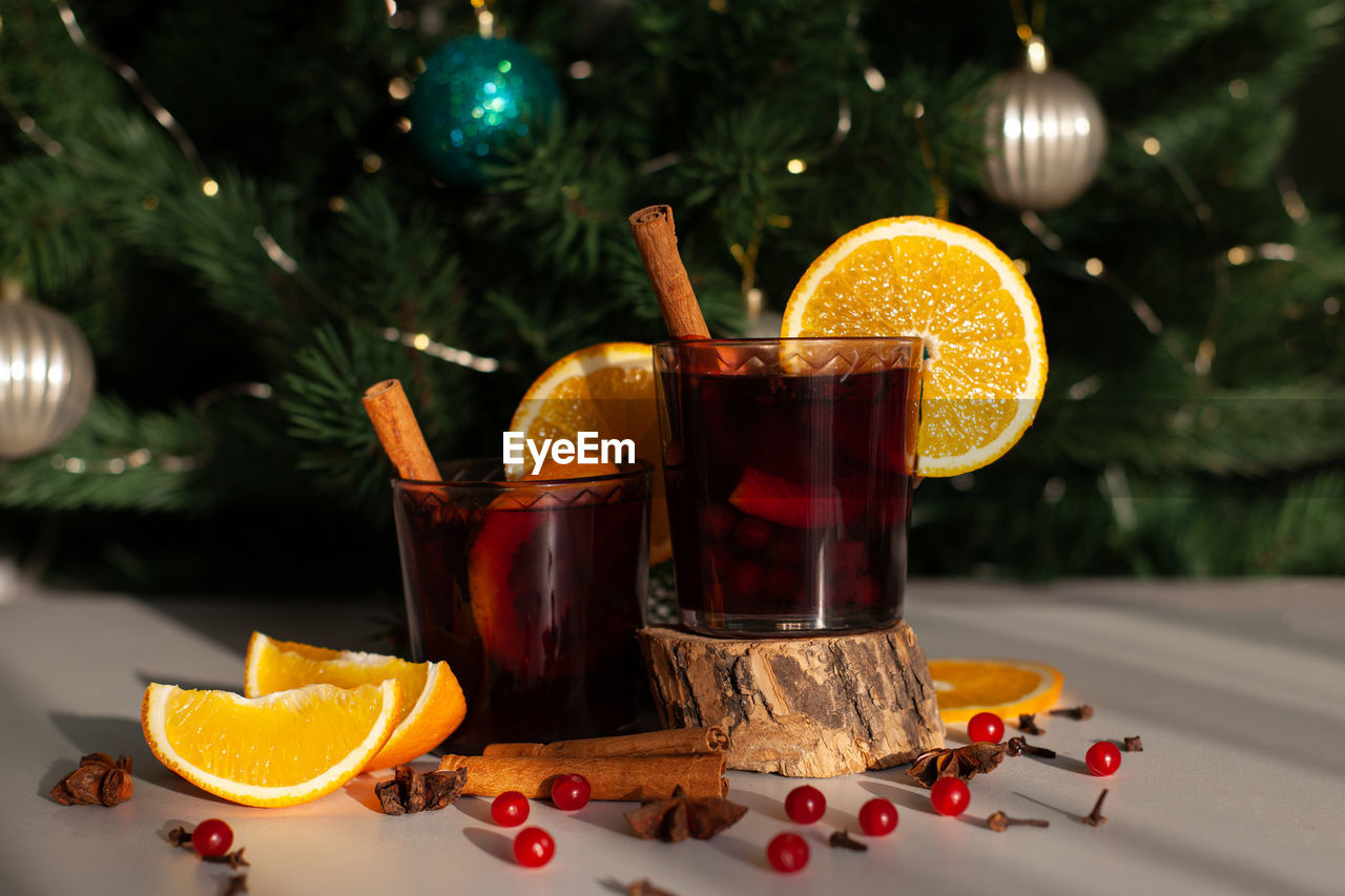 Christmas mulled wine with cinnamon stick, orange, anise and cloves with shadows from sunlight 