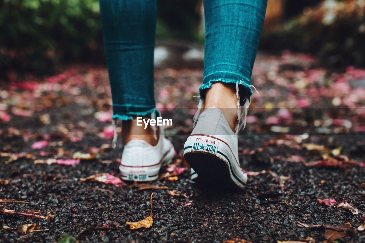 LOW SECTION OF WOMAN STANDING ON COBBLESTONE