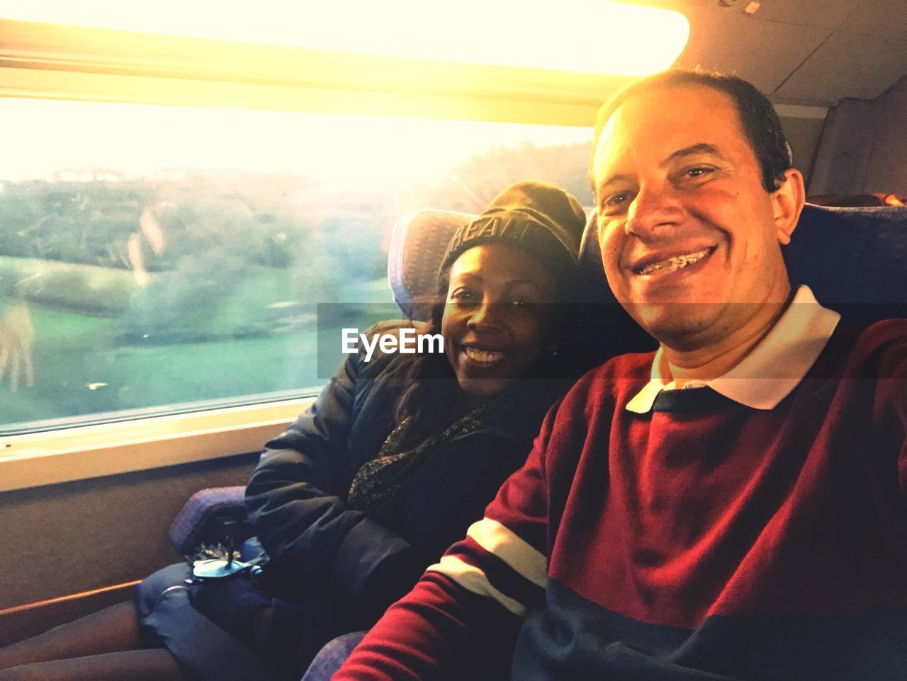 Portrait of smiling couple sitting in train