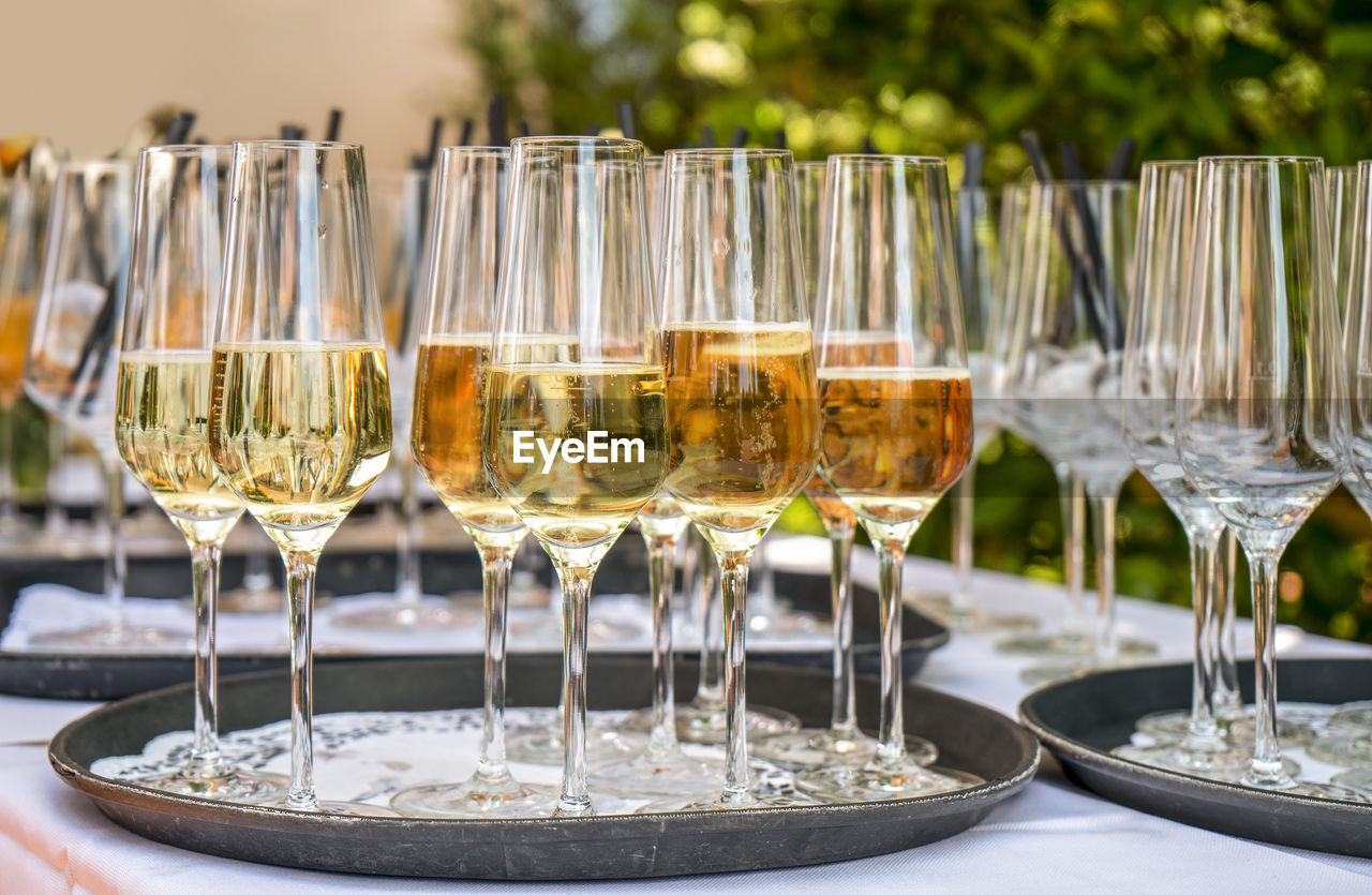 Outdoor garden scenery showing some half filled sparkling wine glasses on a tray