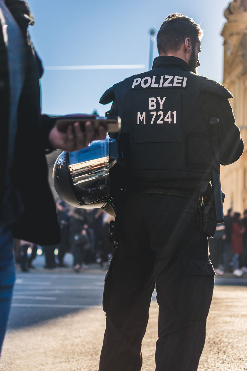police force, law, police officer, government, uniform, security, protection, police, authority, clothing, person, adult, men, occupation, standing, police uniform, day, rear view, outdoors, architecture, city, control