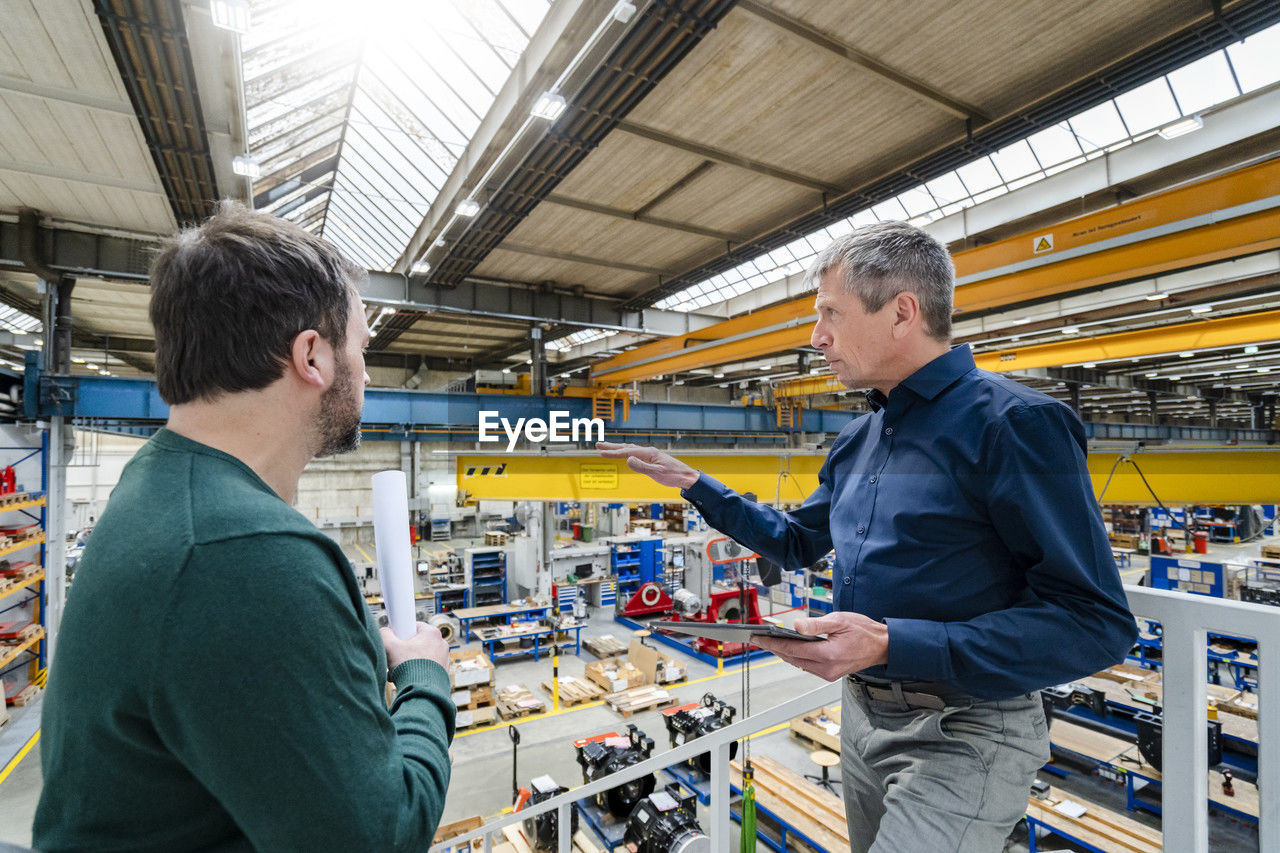 Businessman explaining colleague in factory