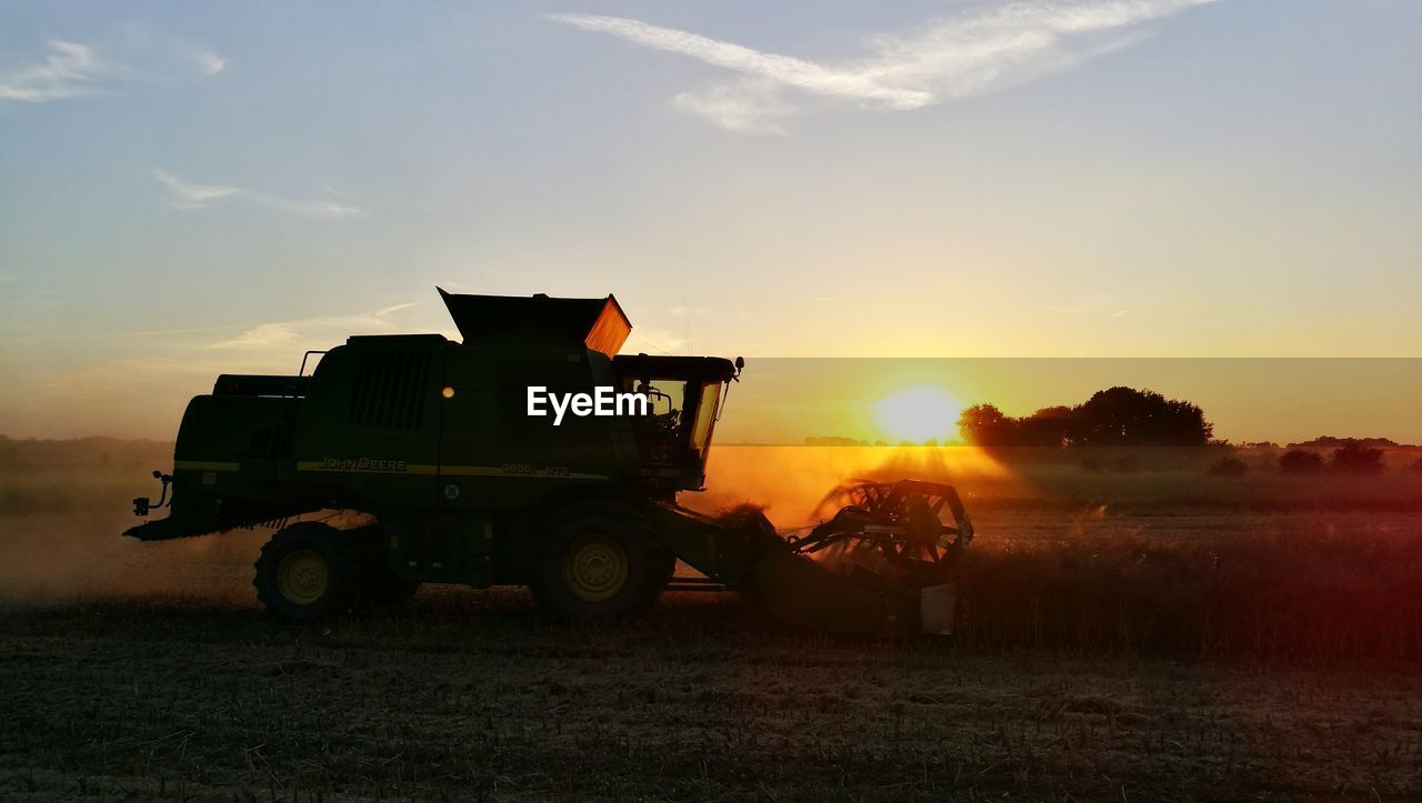 Silhouette agricultural field against sky during sunset