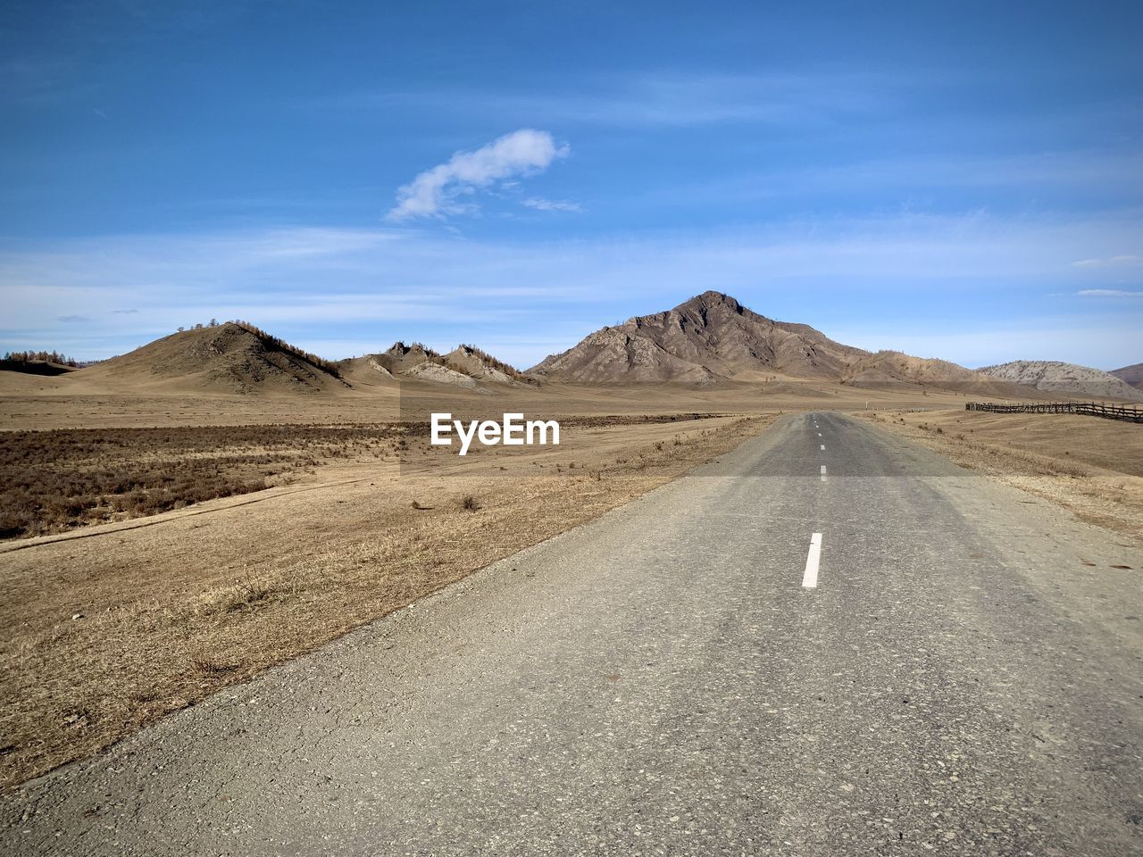 Road amidst desert against sky