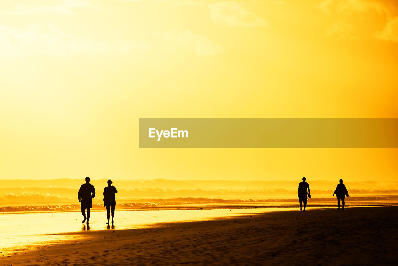 Tourists visiting beach against sky