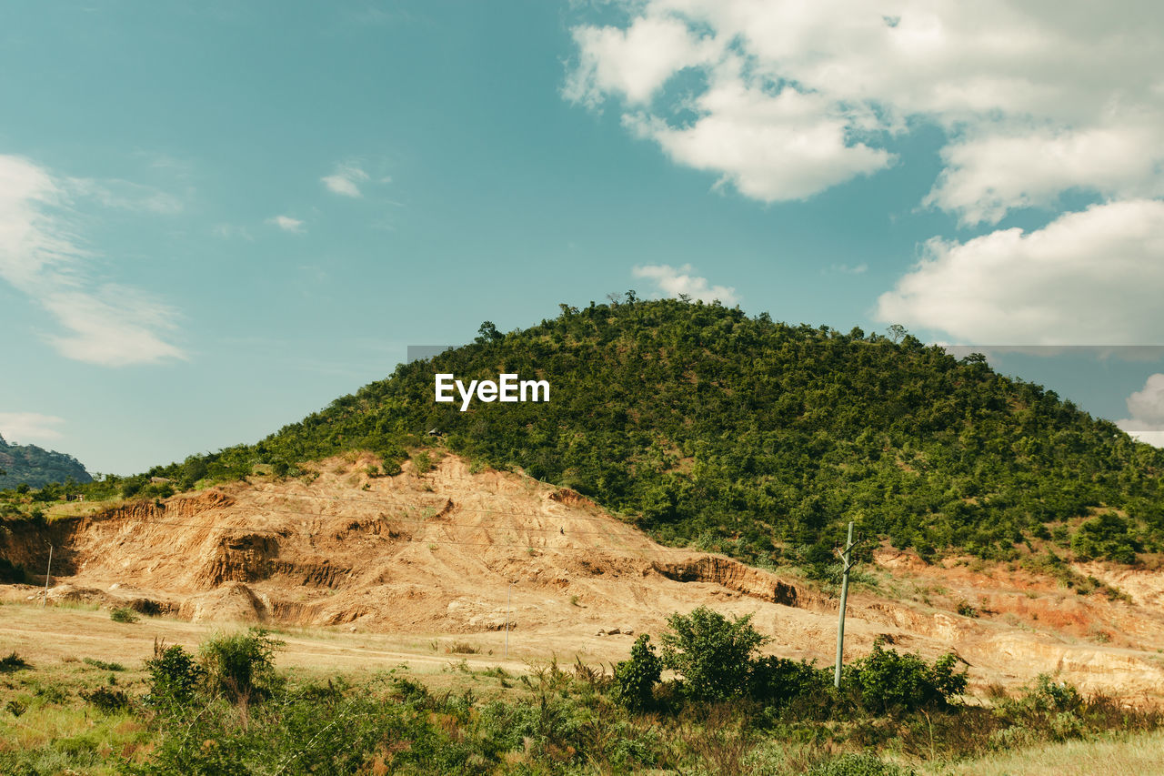Scenic view of land with a mountain against sky
