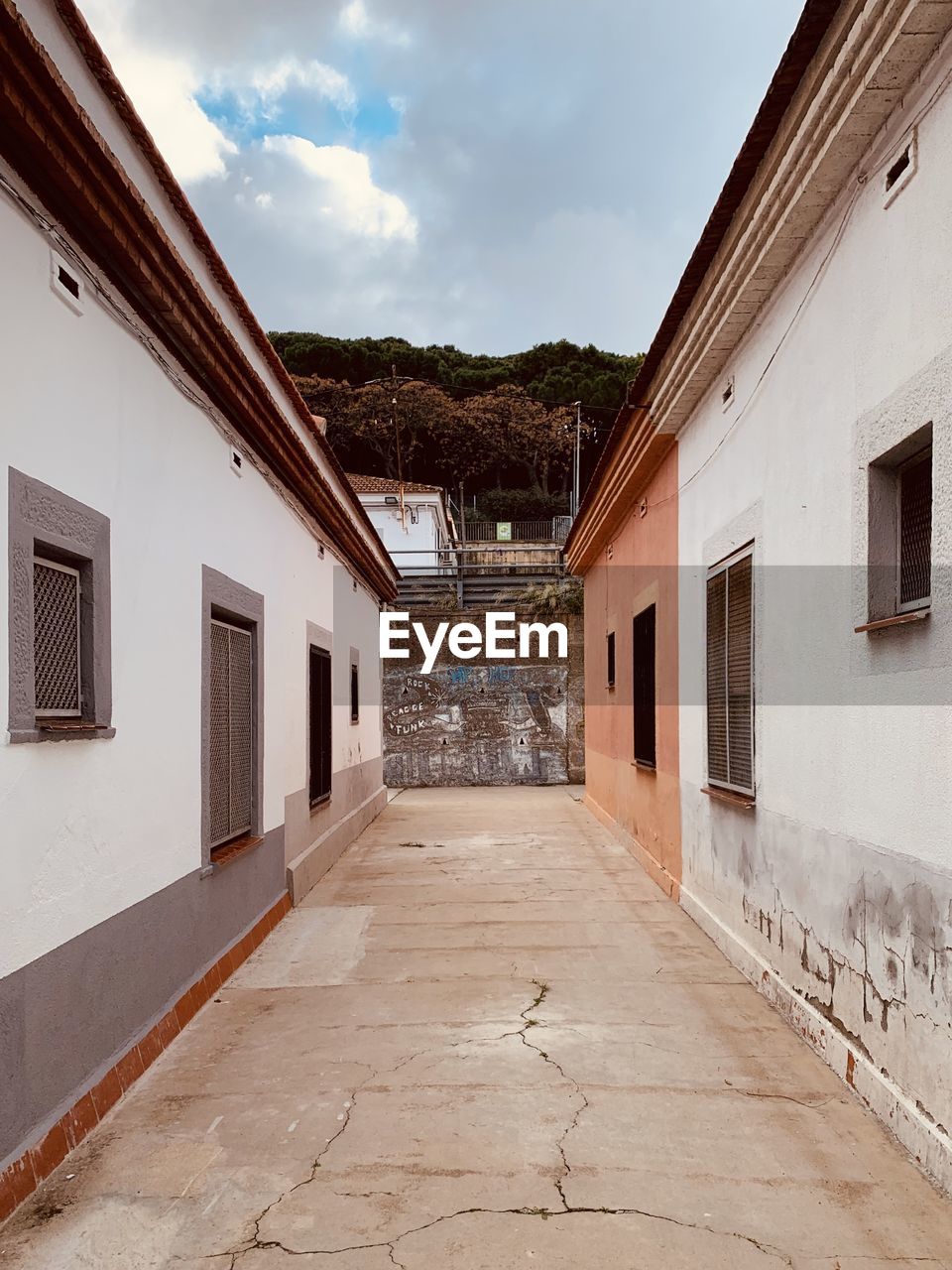 Empty road amidst buildings against sky