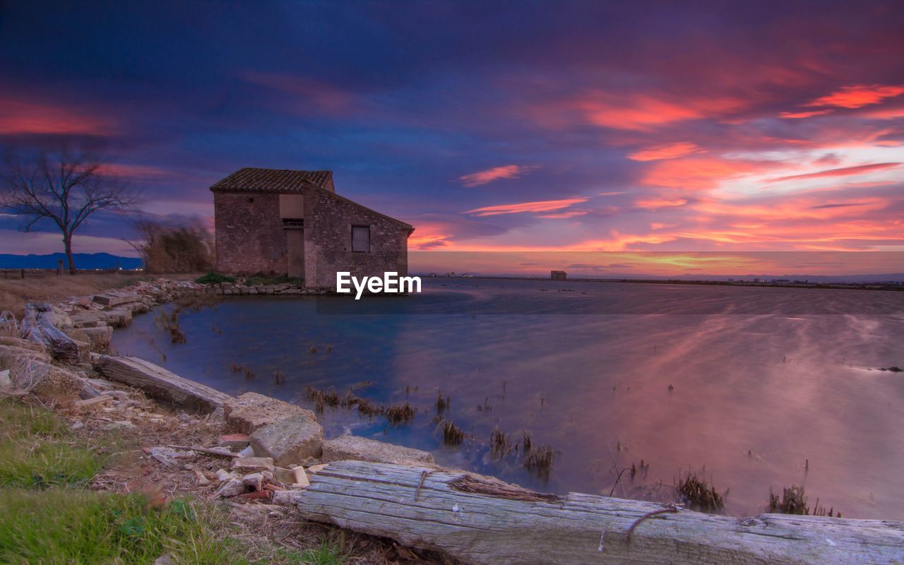 ABANDONED BUILDING BY SEA AGAINST SKY