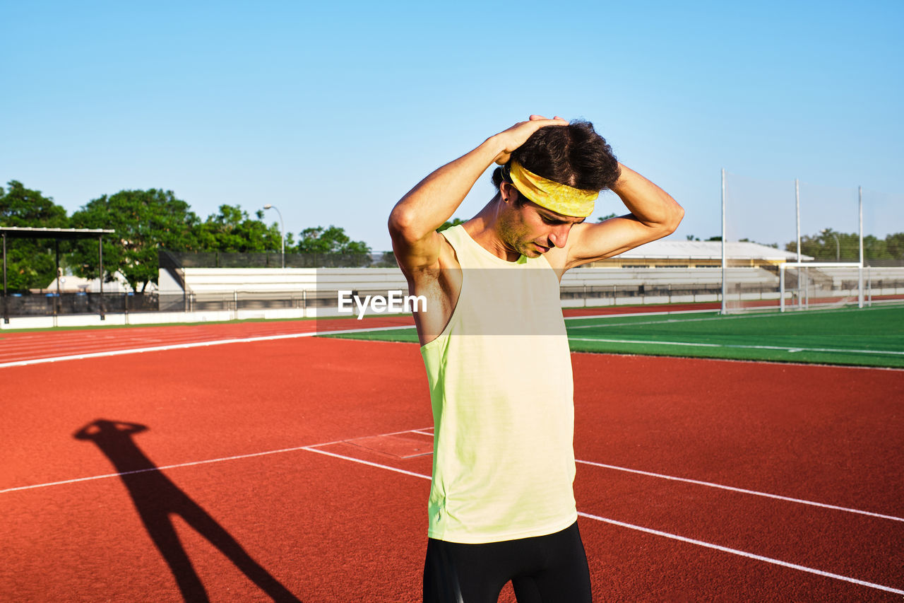 Young man practices his stretches after a hard workout