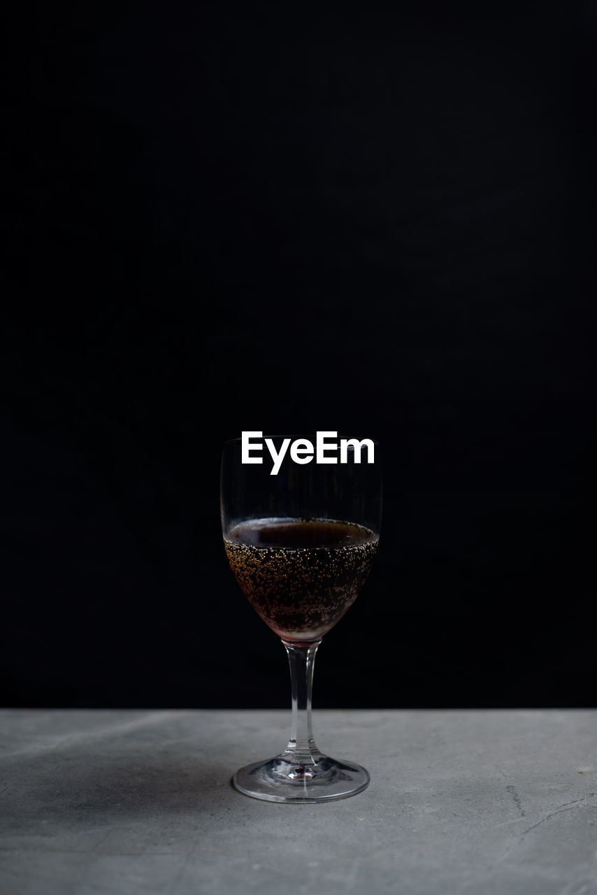 CLOSE-UP OF WINE GLASS ON TABLE