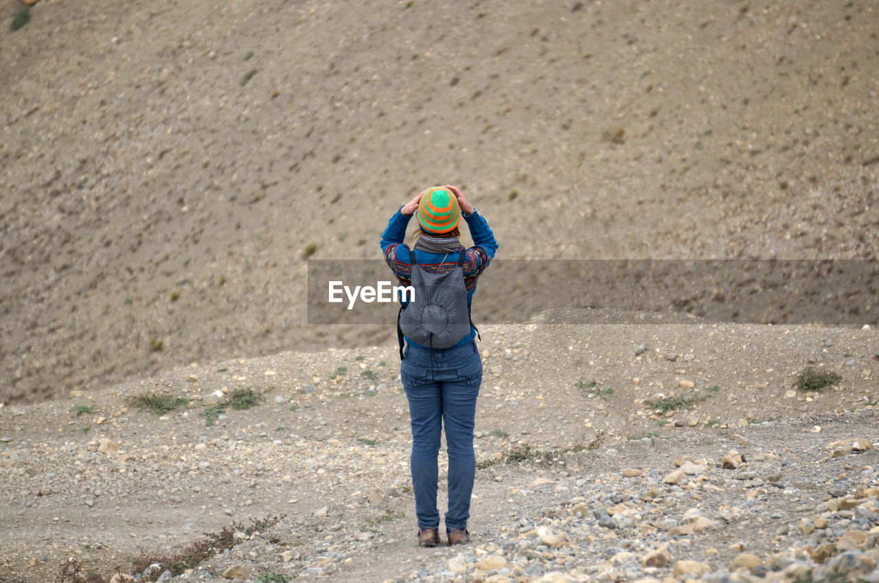 Tourist woman looks at the himalayan mountains, holding her head in her hands.