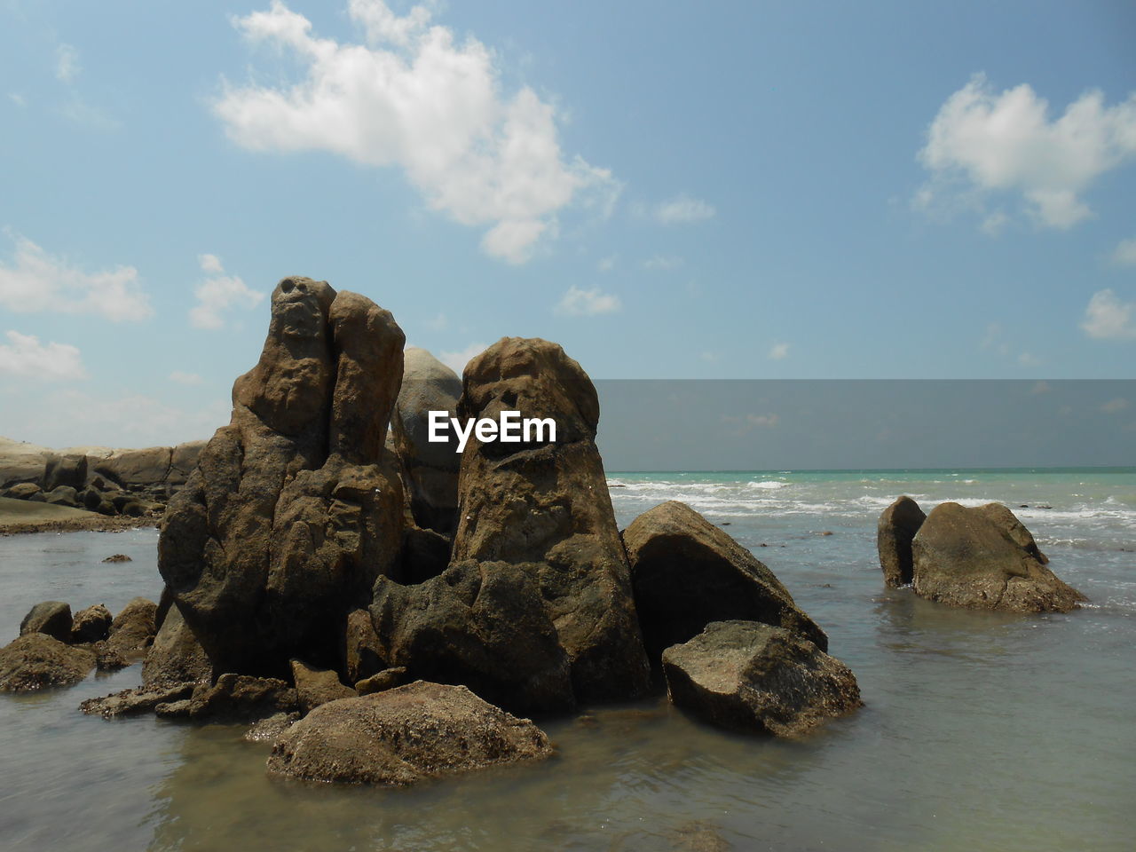 ROCKS ON SHORE AGAINST SKY