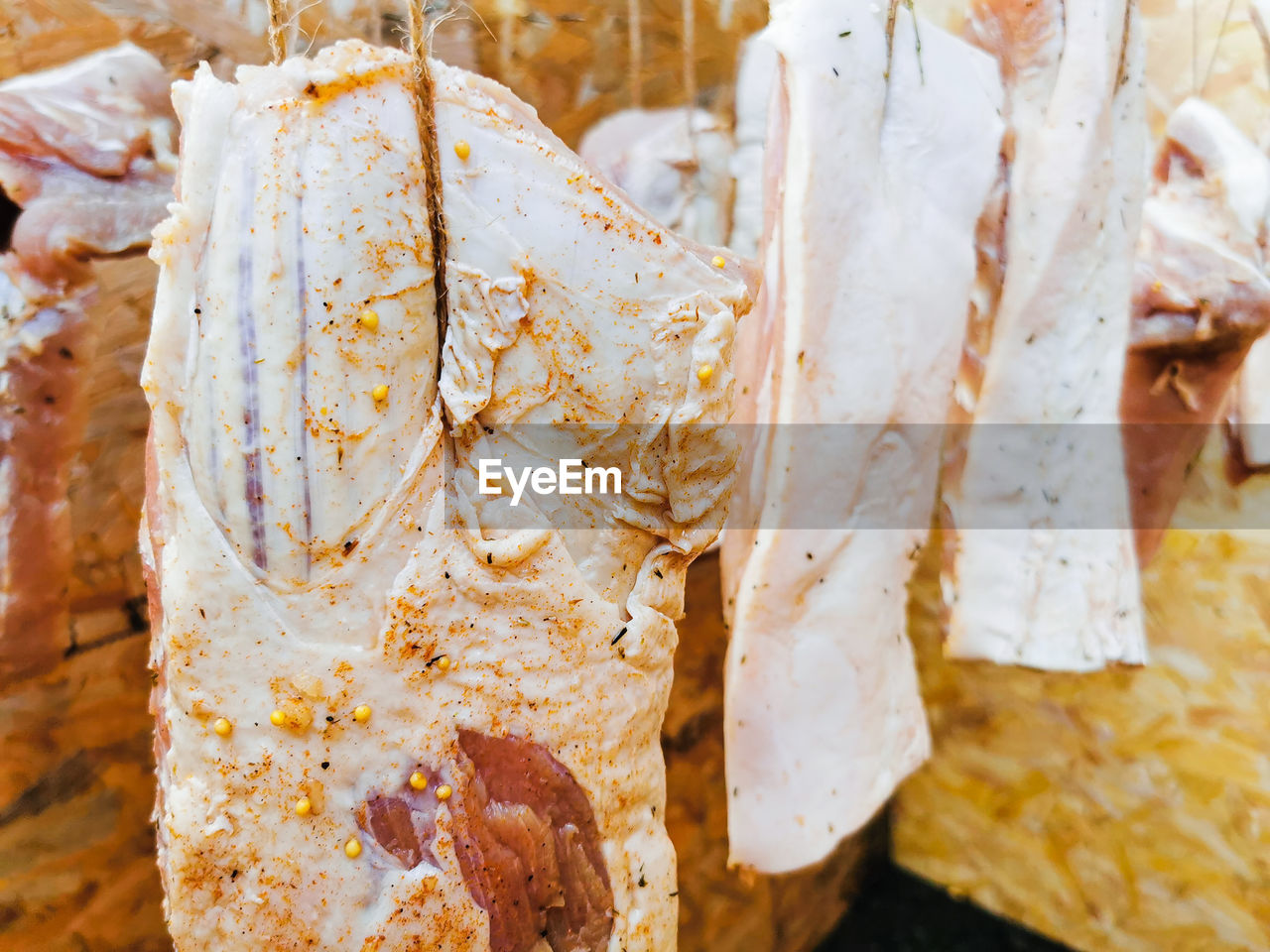 Raw pork meat seasoned and hanged for the smoking process