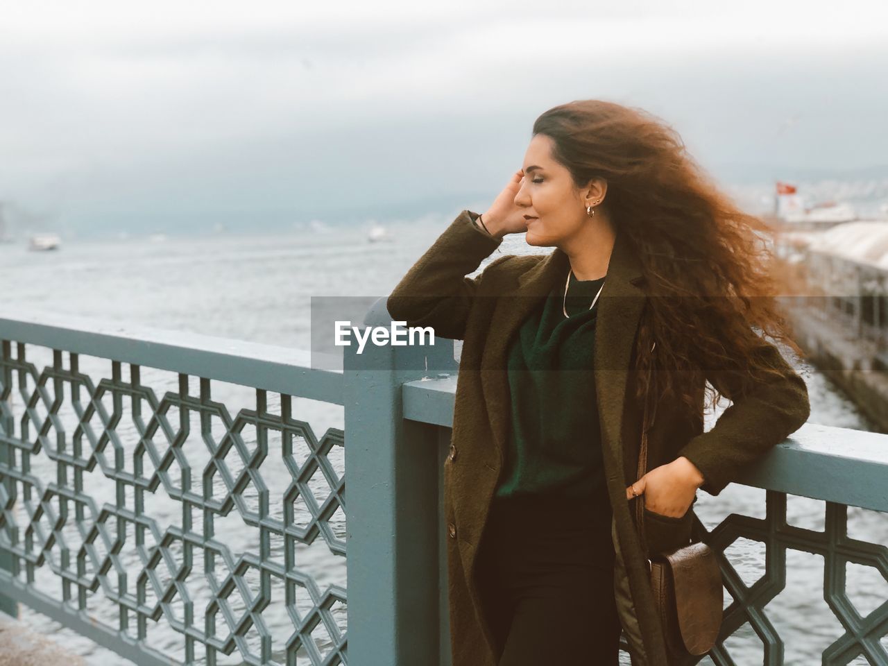 Young woman looking at sea against sky