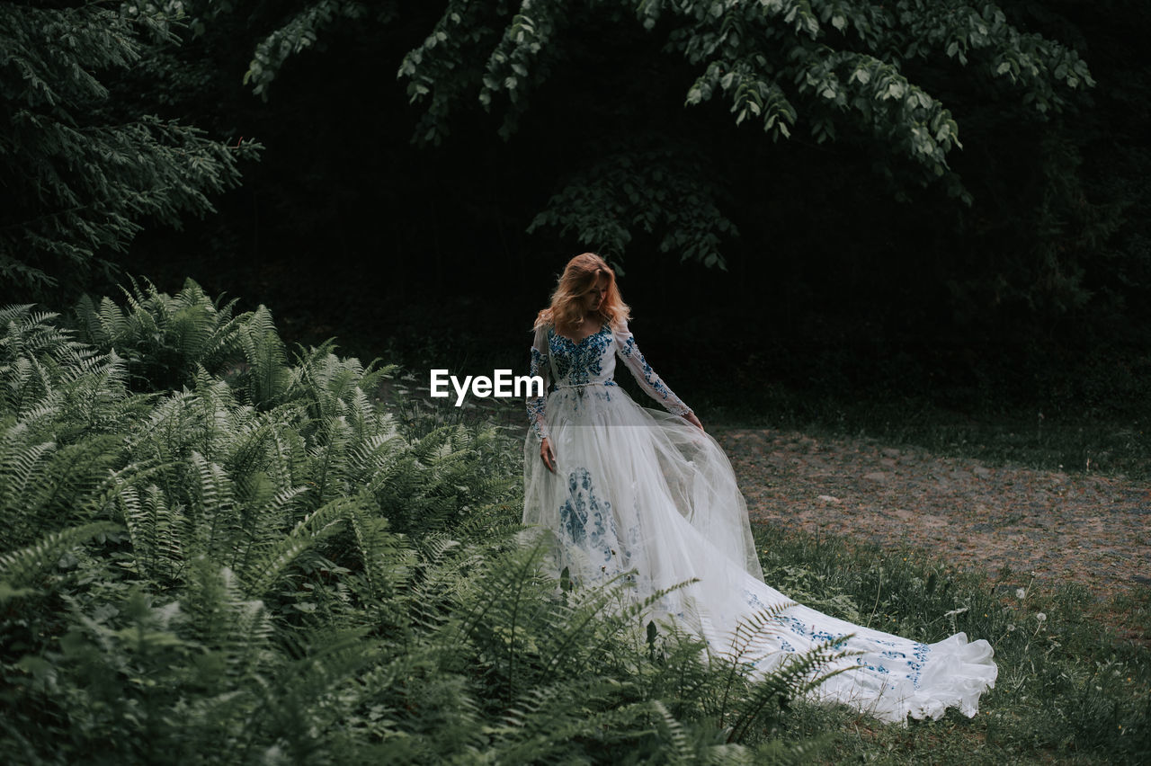 Bride standing by plants