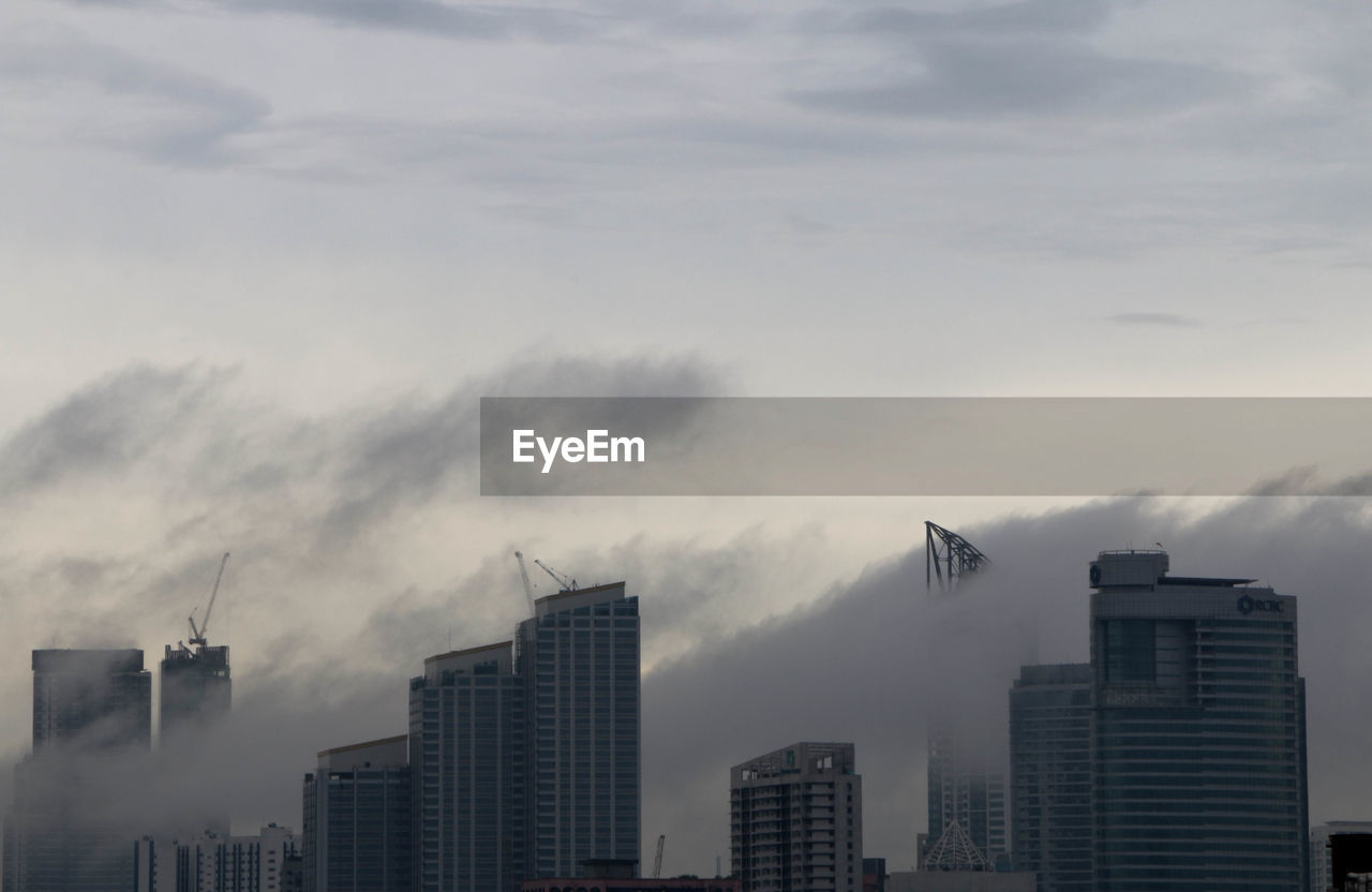 Low angle view of buildings in city against sky during sunset