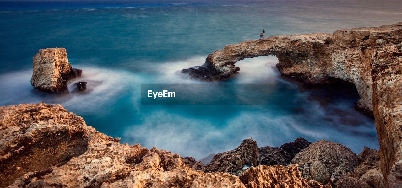 HIGH ANGLE VIEW OF ROCKS IN SEA