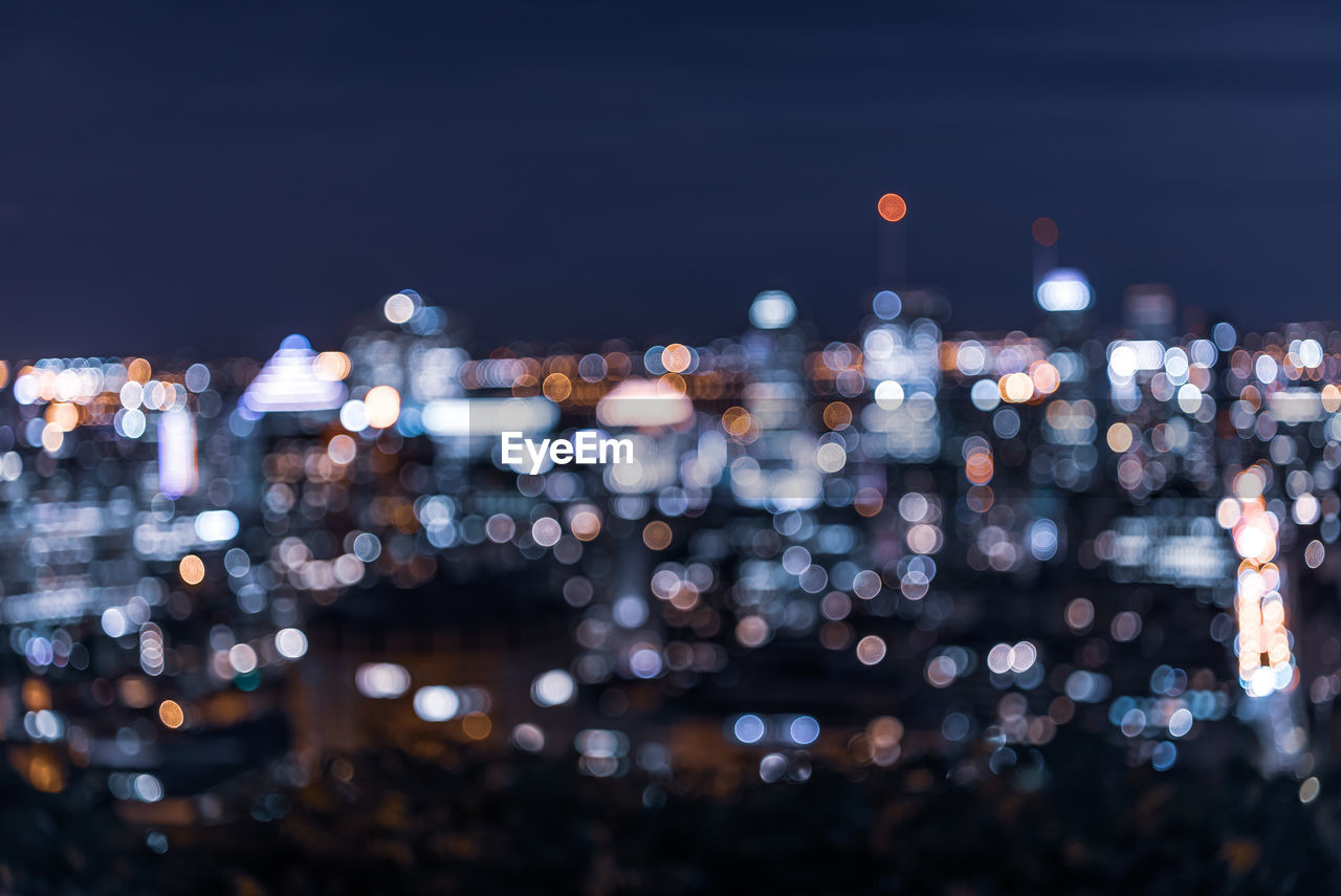 Defocused image of illuminated city buildings at night