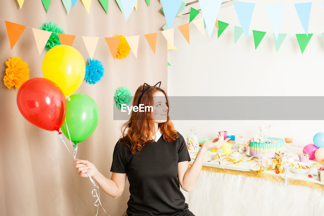 Woman standing on multi colored balloons