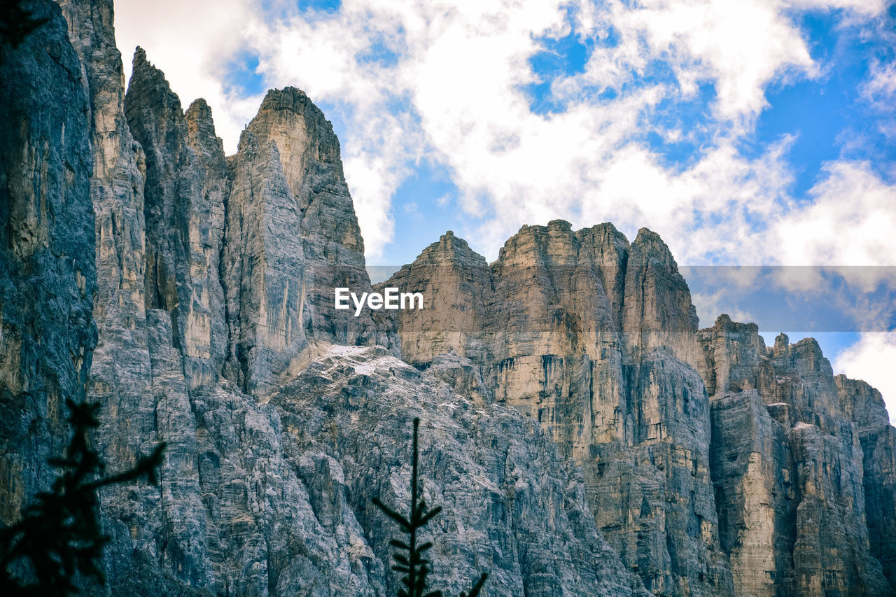 Low angle view of rocky mountains against sky