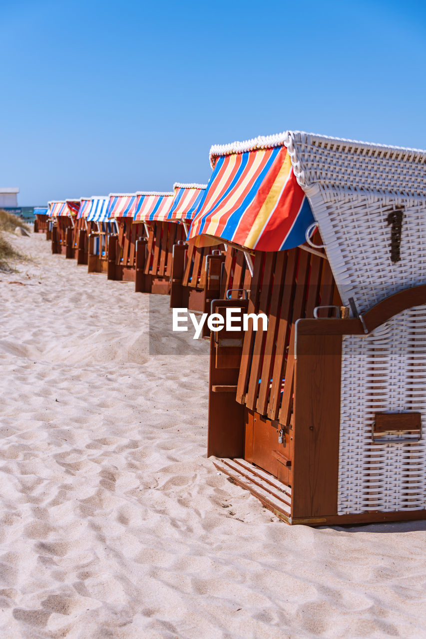 built structures on beach against clear blue sky