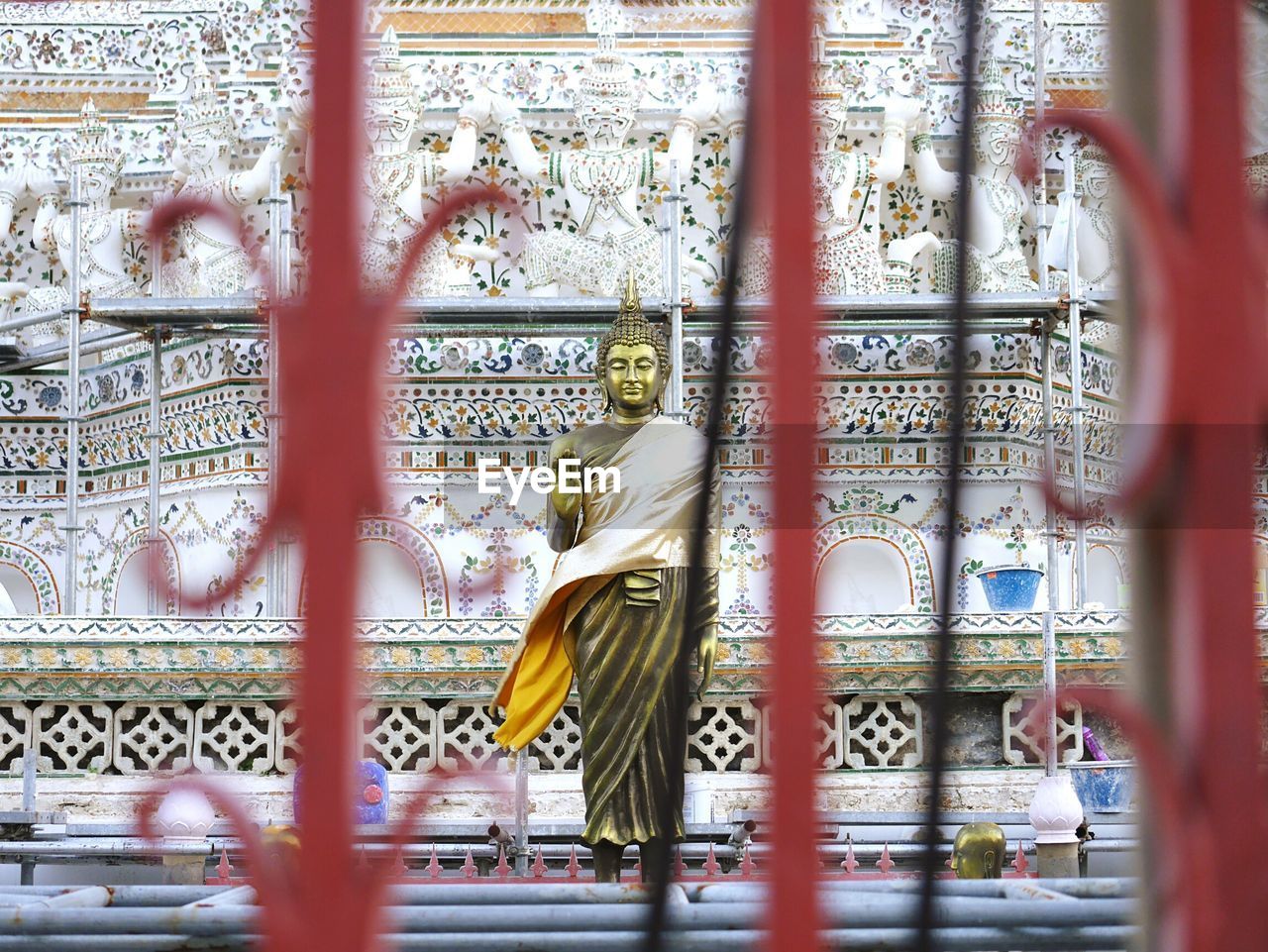 Buddha sculpture seen through railing